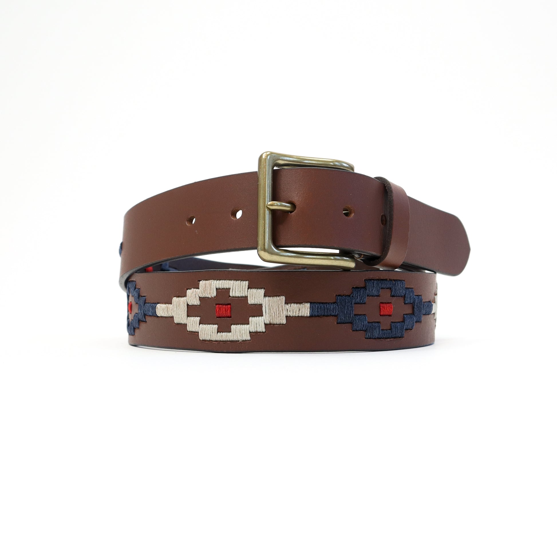 A handmade Italian leather belt featuring a bold red, navy, and white Aztec-patterned woven design, secured with a brass-tone buckle.