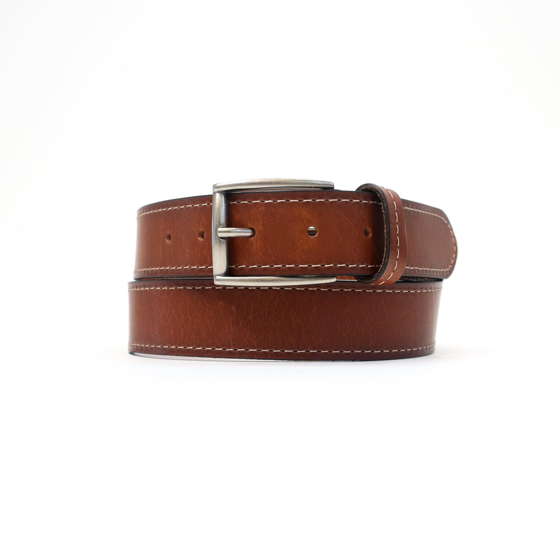 A handmade Italian brown leather belt featuring contrast stitching and a silver-tone buckle, elegantly coiled for a refined look.
