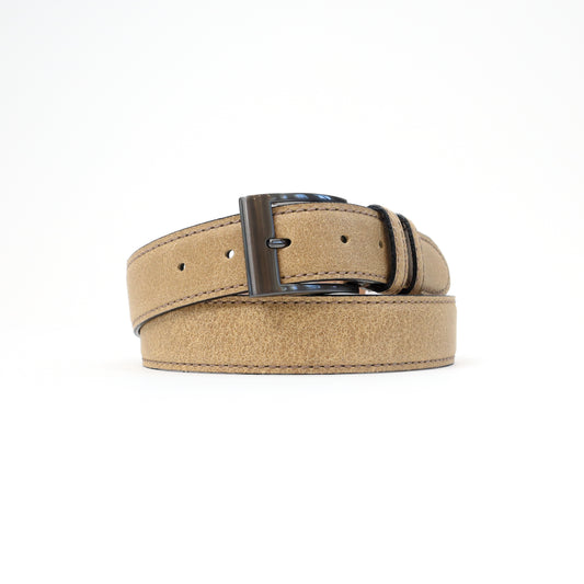A handmade Italian suede belt in soft sand beige, featuring a silver-tone buckle, elegantly rolled for display.

