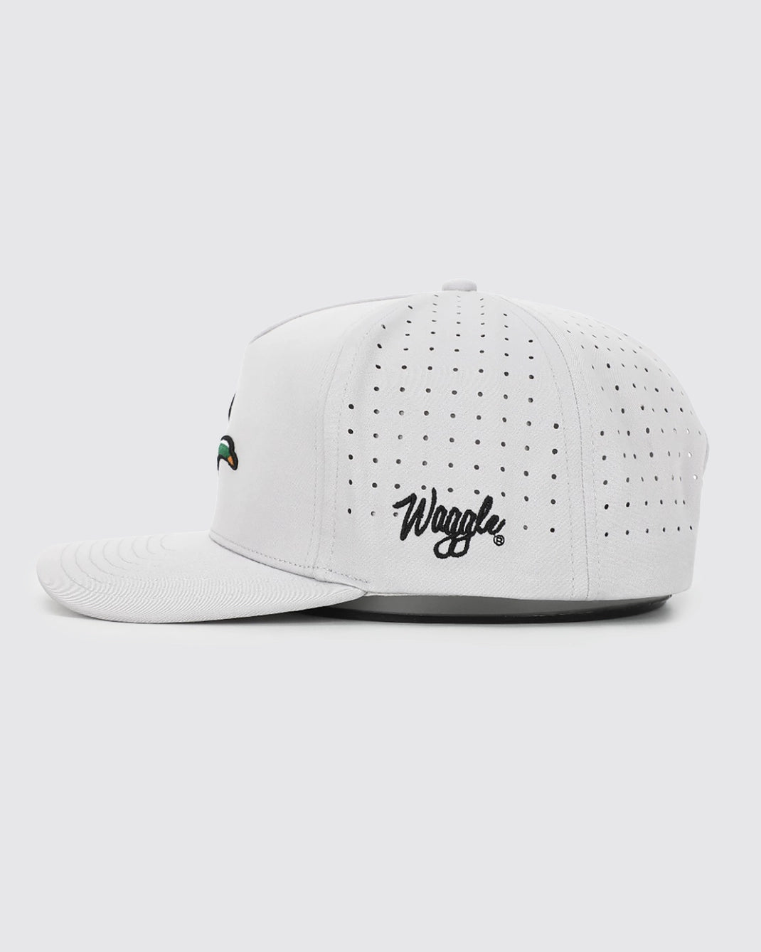 A white structured baseball cap with perforated side panels, featuring the black script 'Wrigley' logo on the front and a small multicolor embroidered logo on the side, shown against a light gray background.